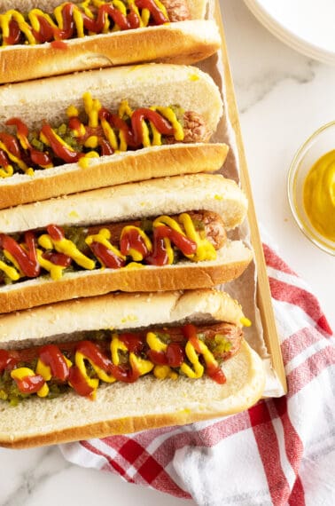 airfryer hot dogs lined up loaded with ketchiup and mustard