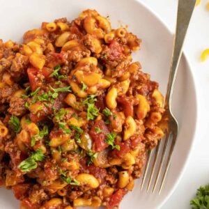 American chop suey on a white plate with a fork