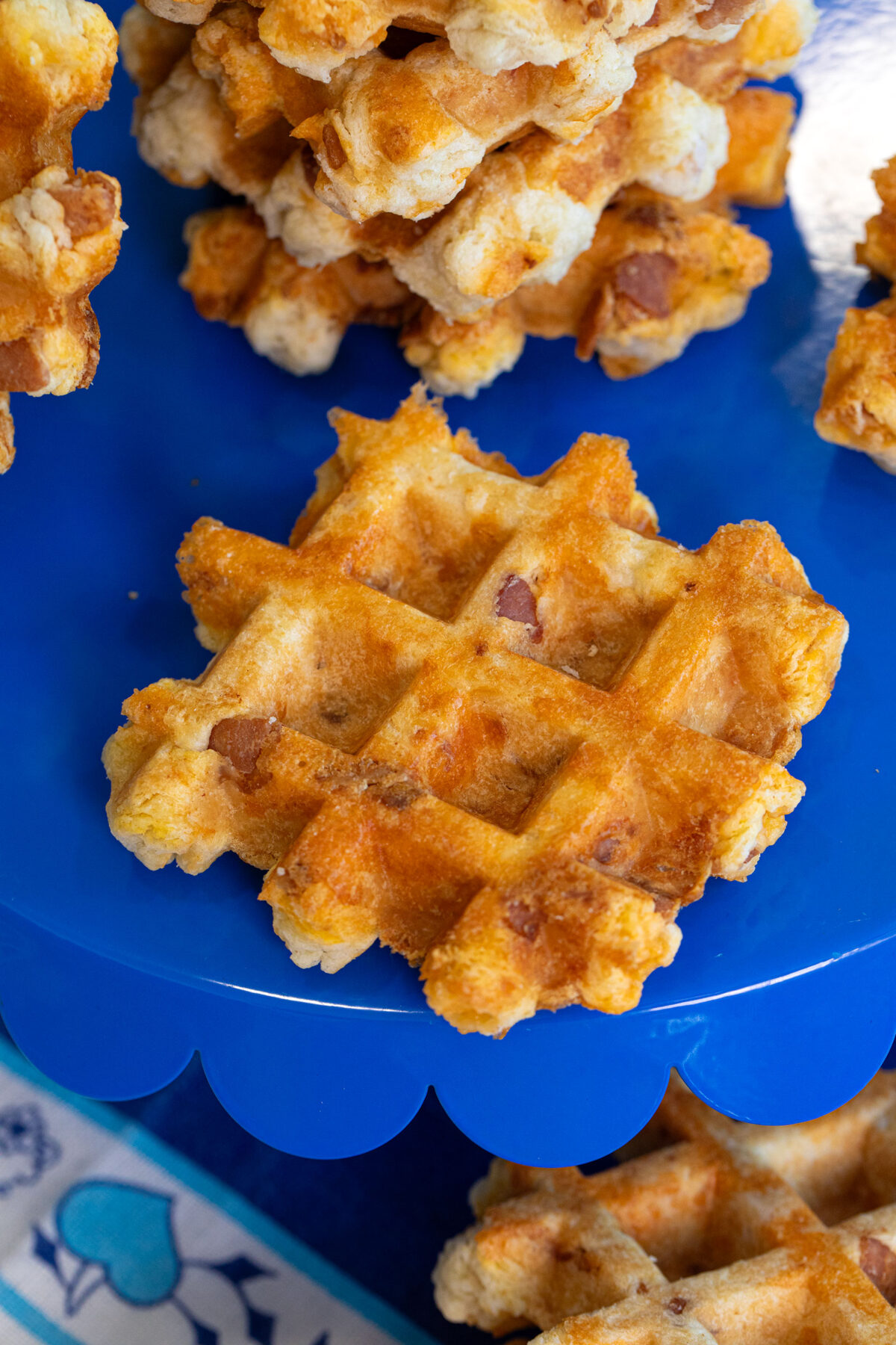 a blue plate with a closeup of Bacon & Cheddar Waffle Biscuits