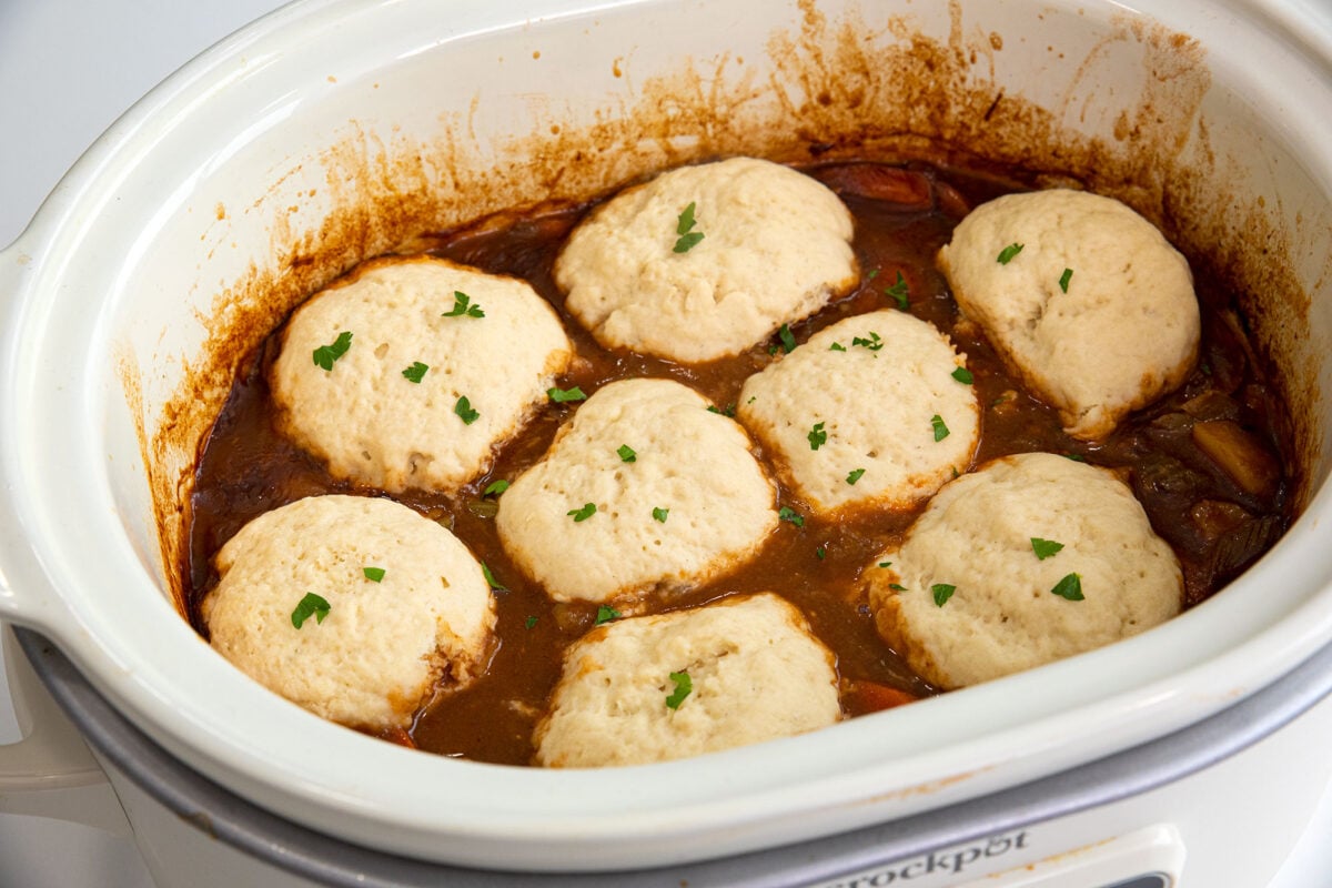 Bisquick dumplings on top of stew in a slow cooker