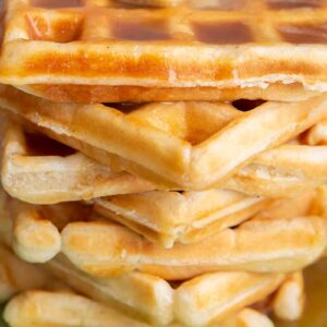 close up stack of fluffy Classic Waffle topped butter and maple syrup