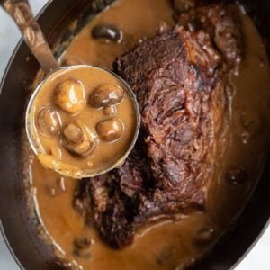 Creamy Mushrooms and Gravy in a Ladle from a slow cooker with Cooked Chuck Roast