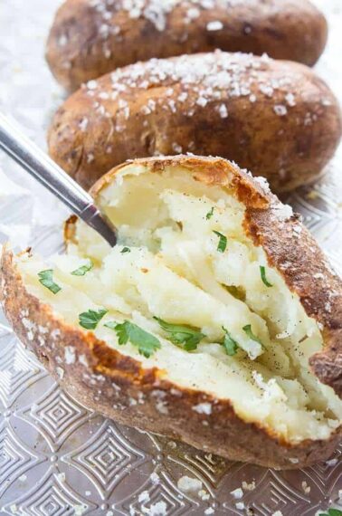 Close up of potato being scooped out by spoon on baking sheet