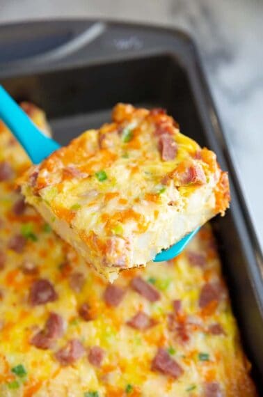 close up slice of hash brown casserole on a turquoise slotted turner