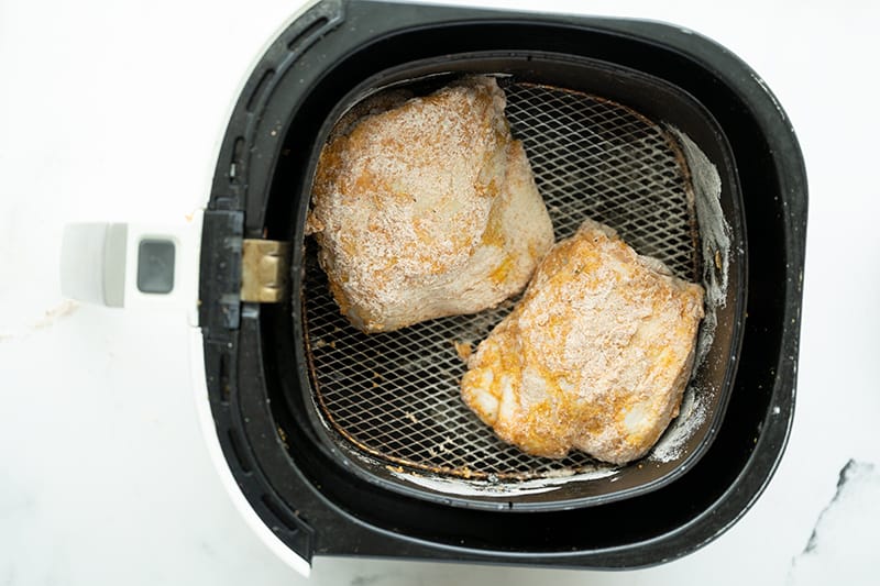 container with chicken inside the air fryer