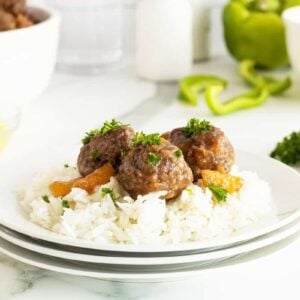 Hawaiian meatballs on top of rice on a white plate