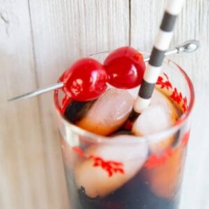 close up Roy Rogers drink in a tall vintage glass, garnished with two maraschino cherries