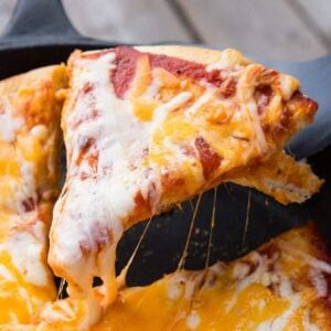 close up slice of cheesy Campfire Pizza from a flat pan