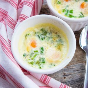 close up Shirred Eggs in a white soup bowl saucers