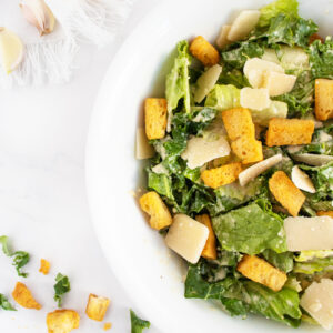 Kale caesar salad close up on white plate