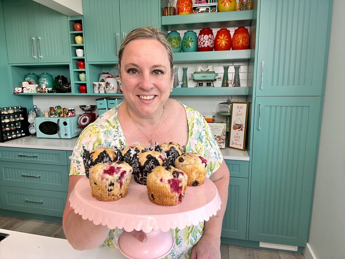 Karlynn Johnston holding a platter of her chocolate raspberry muffins in her kitchen