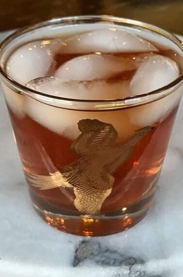 vintage bird glass with ice and Mickie Walker Cocktail on marble background