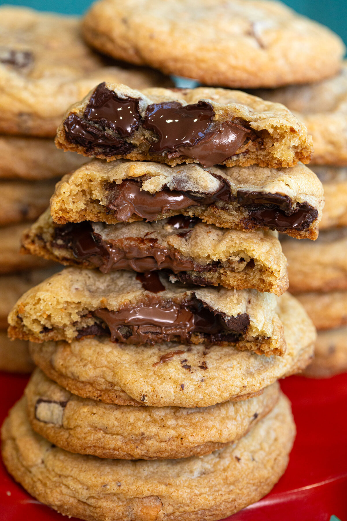 Stack of Nutella stuffed cookies cut in half with the Nutella and chocolate melting out of cookies.