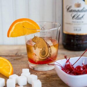 Old Fashioned Cocktail - whisky glass with sugar cube and maraschino cherry Garnish with an orange slice