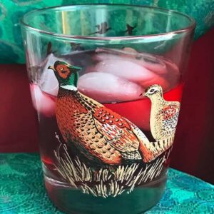 vintage bird glass with oppenheim cocktail and ice on red and green background