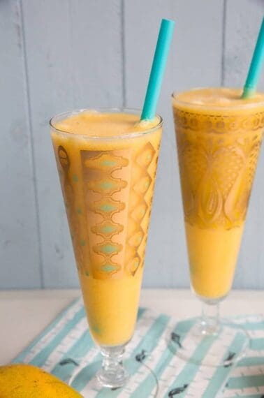 Close up Glasses of Mango Margarita with jade blue straws