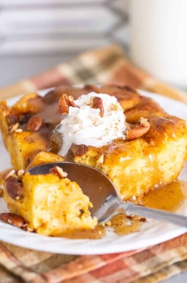 Spooning the Pumpkin Bread Pudding on a white plate