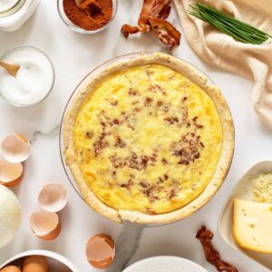 quiche lorraine cooked with ingredients around it