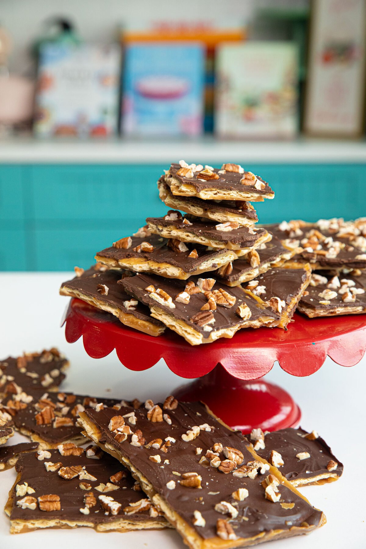 a stack of saltine toffee squares on a red cake stand