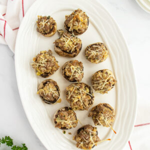 Sausage stuffed mushrooms on a white plate