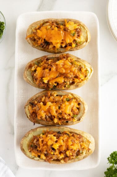 sausage stuffed potatoes on a rectangular white plate