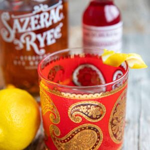 Close-up of a Sazerac cocktail on a wood table.