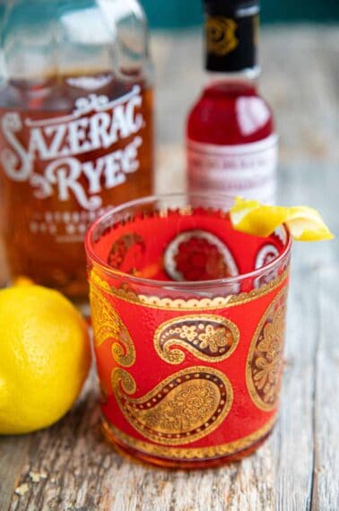 Close-up of a Sazerac cocktail on a wood table.