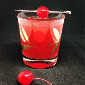 Scofflaw Cocktail on a vintage cocktail glass garnish with a stemmed maraschino cherry