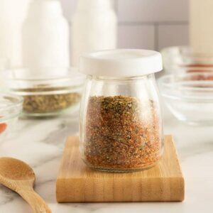 shrimp seasoning in a small tapered clear glass jar on a cutting board