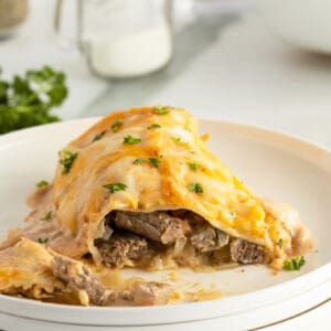 sour cream steak enchilada on a plate sliced showing the streak inside