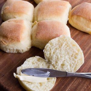 close up spreading honey butter into Sweet Dinner Rolls using spread knife