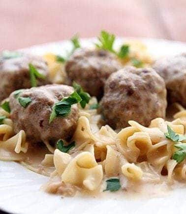 Close up Turkey Swedish Meatballs served over egg noodles garnished with parsley leaves