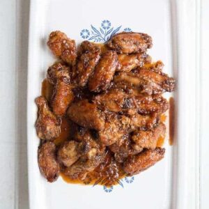 Saucy Japanese Chicken Wings in a white serving tray on white background