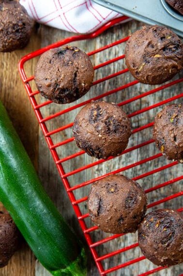 close up Brownie Bites in a red wire rack, whole zucchini beside it